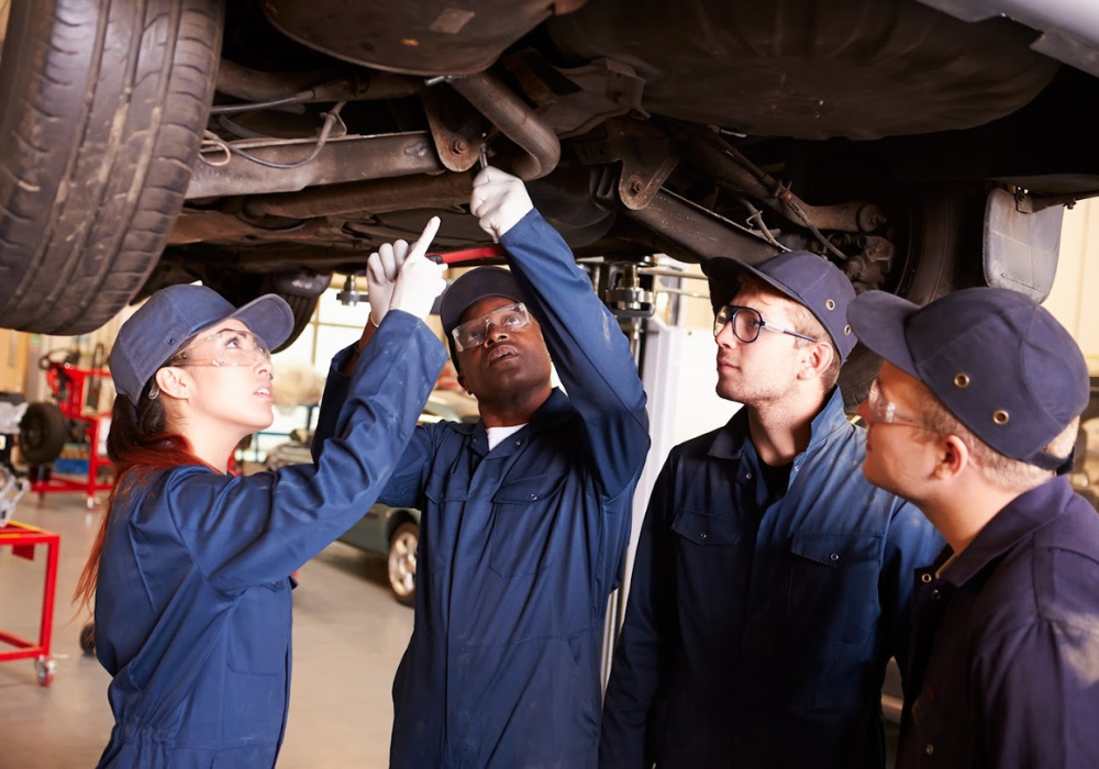 Vehicle technicians at work on a car in a garage